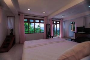 una camera da letto con un grande letto con pareti e finestre rosa di Cielo Residence a Kandy