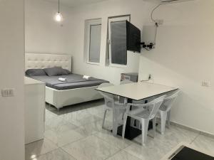 a small room with a bed and a table and chairs at Golem Apartment in Golem