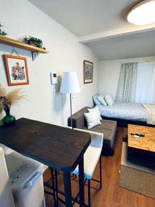 Yokohama Ivy 103 - 横浜アイビー清水ヶ丘103 - في يوكوهاما: غرفة معيشة صغيرة مع سرير وأريكة