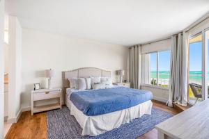 a bedroom with a bed and a large window at Hutchinson Island Beach Condo in Fort Pierce +30 photos