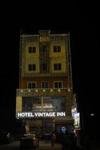 蒂鲁帕蒂Hotel Vintage inn的一栋带有酒店的建筑，晚上有一家复古旅馆