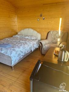 a bedroom with a bed and a chair and a table at Eco Aura (rest zone / Sevan / Отдых) in Areguni