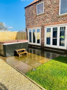 una panchina seduta di fronte a un edificio di mattoni di Barn near York with hot tub - Perfect for Groups and Families a York
