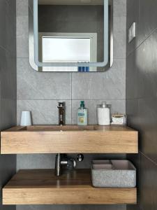 ein Badezimmer mit Waschbecken und Spiegel in der Unterkunft L'Obsidienne in Virecourt + 24 Fotos