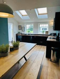 una grande cucina con pavimento in legno e finestre di Barn near York with hot tub - Perfect for Groups and Families a York