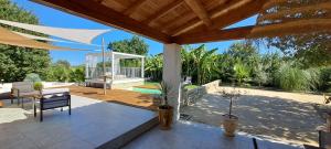 a patio with a wooden deck with a pergola at Ginatella - 3 chambres in Deaux