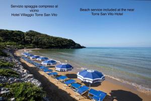 a group of blue umbrellas and chairs on a beach at Dimora del Leone Gaeta in Gaeta