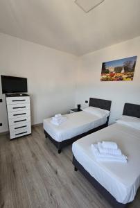 a room with two beds and a flat screen tv at Lake View in Meina