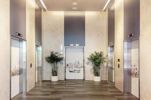 an elevator lobby with two potted plants at Hotel COZi Harbour View in Hong Kong