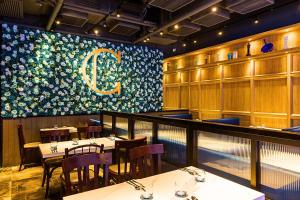 a restaurant with tables and chairs and a large floral wall at Hotel COZi Harbour View in Hong Kong