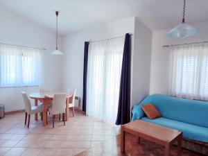 a living room with a blue couch and a table at Apartments Jurjevic in Petrcane