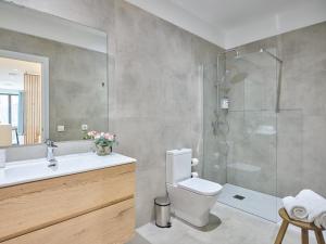 a bathroom with a shower and a toilet and a sink at Paseo Suites Hotel in Madrid