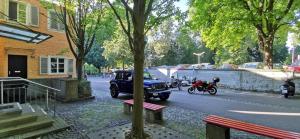 a car driving down a street with a person on a motorcycle at Apartment mit Parkblick Lindau Bodensee Insel in Lindau