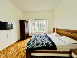 un dormitorio con una cama y una ventana en Teyt's Green Haven - 3 BHK, en Ooty