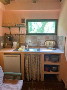 Una pequeña cocina con fregadero y ventana. en Guest house Pikec, en Bezdan