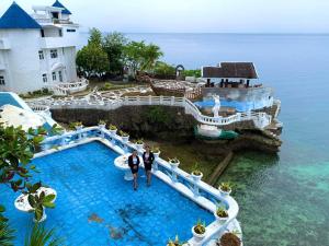two people standing in the water at a resort at Azure Camotes Resort Hotel in Puerto Bello