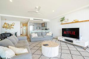 a living room with a couch and a tv at Absolute Kirra by EcoTime in Gold Coast