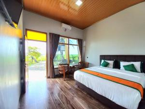 une chambre avec un lit, un bureau et une fenêtre dans l'établissement Hotel Syariah Simply Homy dekat Yogyakarta International Airport, à Glagah