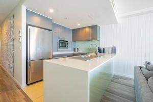 a kitchen with a white counter and a refrigerator at Absolute Kirra by EcoTime in Gold Coast