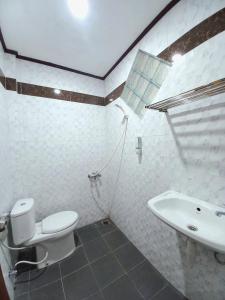 une salle de bains avec toilettes et lavabo dans l'établissement Hotel Syariah Simply Homy dekat Yogyakarta International Airport, à Glagah