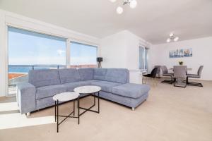 a living room with a blue couch and a table at Schmidt veliki in Dramalj
