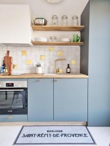 Centre St Rémy - le Mas Bohème في سان ريمي دو بروفنس: مطبخ مع خزائن زرقاء ومغسلة +32 صورة