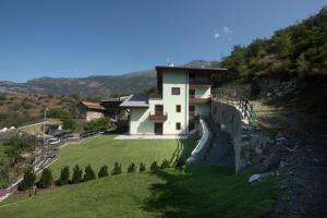 a house on the side of a hill with a green yard at appartamenti Suly 1 cir0082 in Saint Vincent
