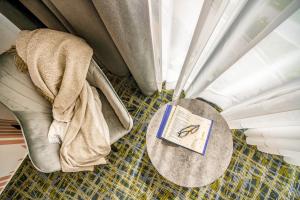 Ein Buch liegt auf einem Bett mit Vorhängen. in der Unterkunft B1 City Hotel Sofia in Sofia + 34 Fotos