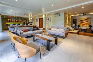 a living room with couches and chairs and a table at Da Vinci The Villa by Nagisa Bali in Tumbak Bayuh +28 photos