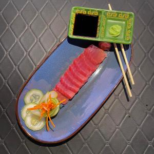 a plate of food with sushi and vegetables on chopsticks at Mojo Hostel in Puerto Princesa City