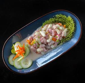 a blue plate of food with vegetables on a table at Mojo Hostel in Puerto Princesa City