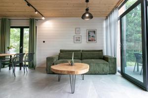 a living room with a green couch and a table at Stodoła Potołówek in Potołówek