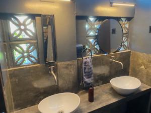 a bathroom with two sinks and a mirror at Mojo Hostel in Puerto Princesa City