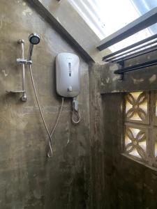 a bathroom with a soap dispenser on the wall at Mojo Hostel in Puerto Princesa City