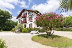 une voiture blanche garée devant une maison dans l'établissement Domaine de Bellegarde, à Soustons