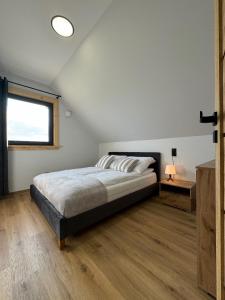 a bedroom with a bed and a window at Domek DE-Luxe BUFLAK in Nowy Targ