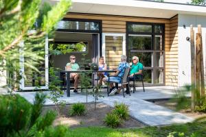 a group of people sitting at a table on a patio at Bospark Ede in Ede