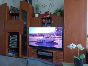 a television in a entertainment center with a car on the screen at Briedis un partneri in Cēsis