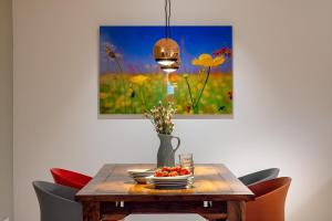 ein Esstisch mit einer Vase mit Blumen darauf in der Unterkunft TempelCasa Kreuzberg in Berlin + 9 Fotos