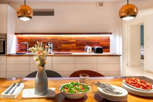 einen Holztisch mit einer Vase aus Blumen und einer Schüssel Essen in der Unterkunft TempelCasa Kreuzberg in Berlin