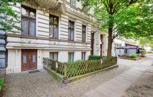 ein weißes Gebäude mit einem Zaun davor in der Unterkunft TempelCasa Kreuzberg in Berlin