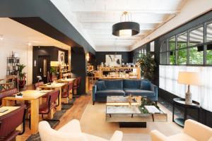 a restaurant with a blue couch and tables and chairs at La França Travellers Adults Only in Barcelona