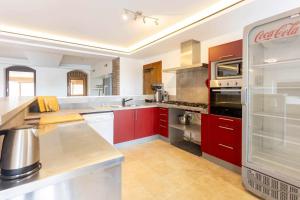 a large kitchen with red cabinets and appliances at Auberge de la Fagne in Malmedy