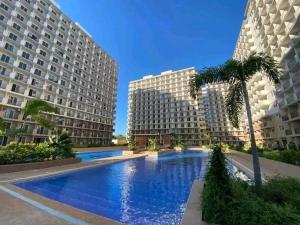 a large swimming pool with two tall buildings at Lai Stay in Lapu Lapu City