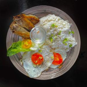 a plate of food with rice and meat and vegetables at Mojo Hostel in Puerto Princesa City