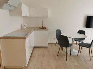 a kitchen with a table and chairs and a table and a table and chairs at Ragainės apartamentai in Klaipėda