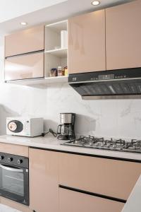 a kitchen with a stove and a microwave at Greyscape Apple Tree Apartment in Nairobi