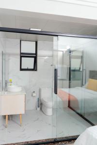 a bathroom with a glass shower and a toilet at Greyscape Apple Tree Apartment in Nairobi