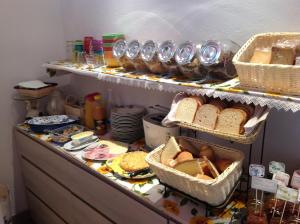 a shelf filled with bread and baskets of food at Florivana Boutique Hotel in San Pietro in Cariano +90 photos