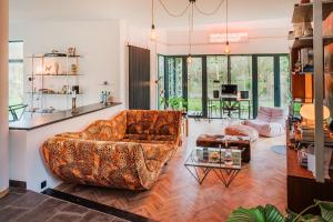 a living room with a couch and a table at Pinecone Hideaway - huis in het bos in Aalter